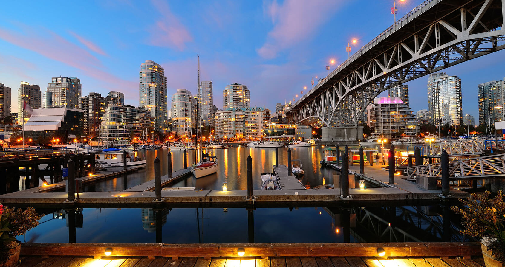 Vancouver Falso Creek por la noche con puente y barco.